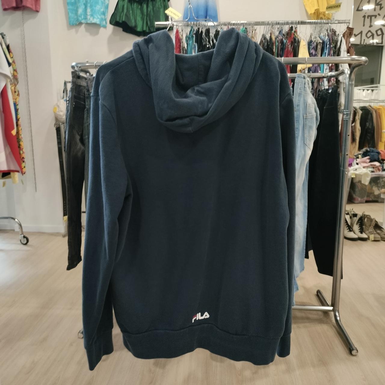 Dark blue hoodie with a brand logo on a clothing rack in a store