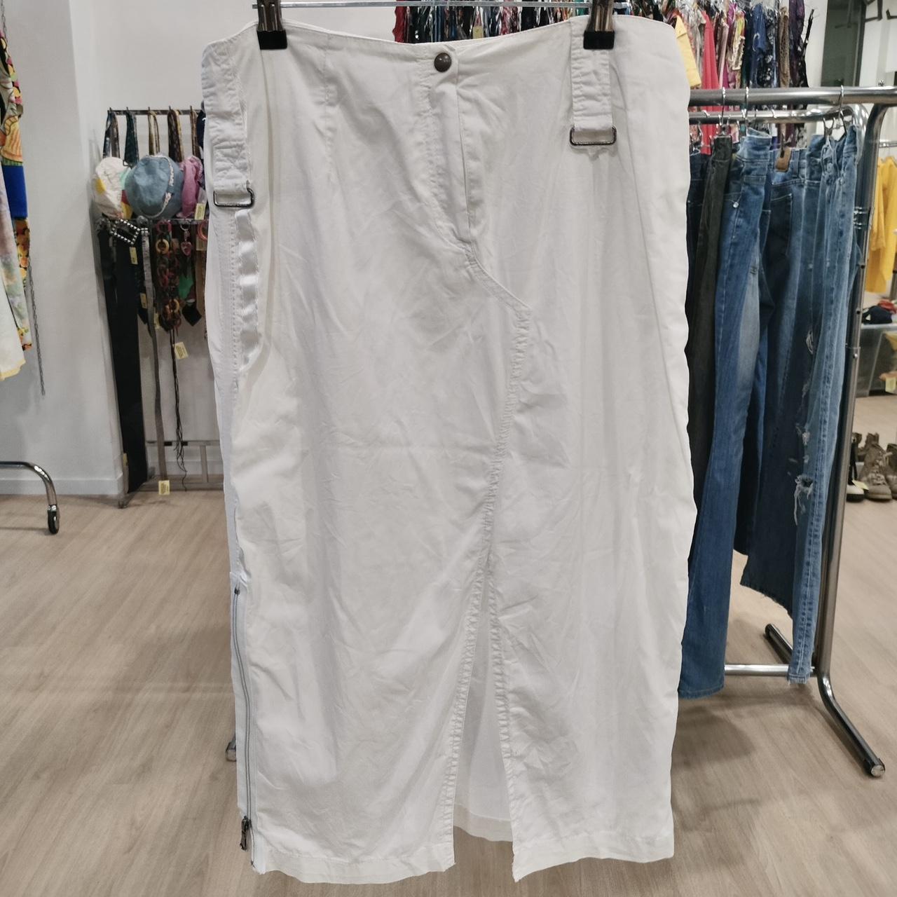 White midi skirt with front button and side buckles in a second hand fashion store