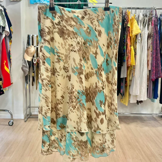 Beige midi skirt with brown and teal abstract pattern, displayed in a secondhand clothing store