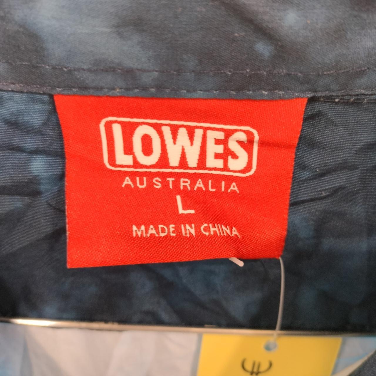 Close-up of red clothing label with size L and 'made in China' text on a blue garment