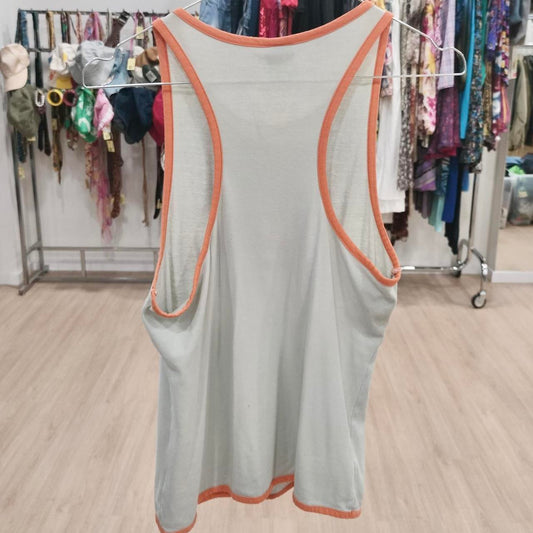Light grey racerback tank top with orange trim, displayed in a second hand clothing store