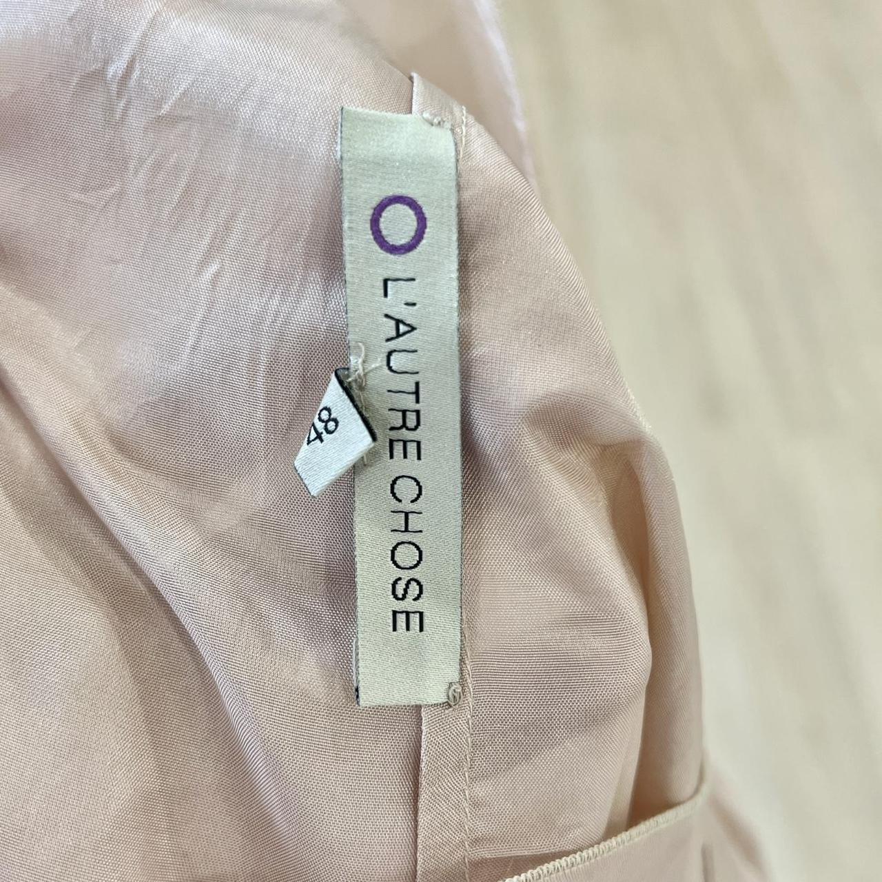 Close-up of a beige garment with a 'L'Autre Chose' label