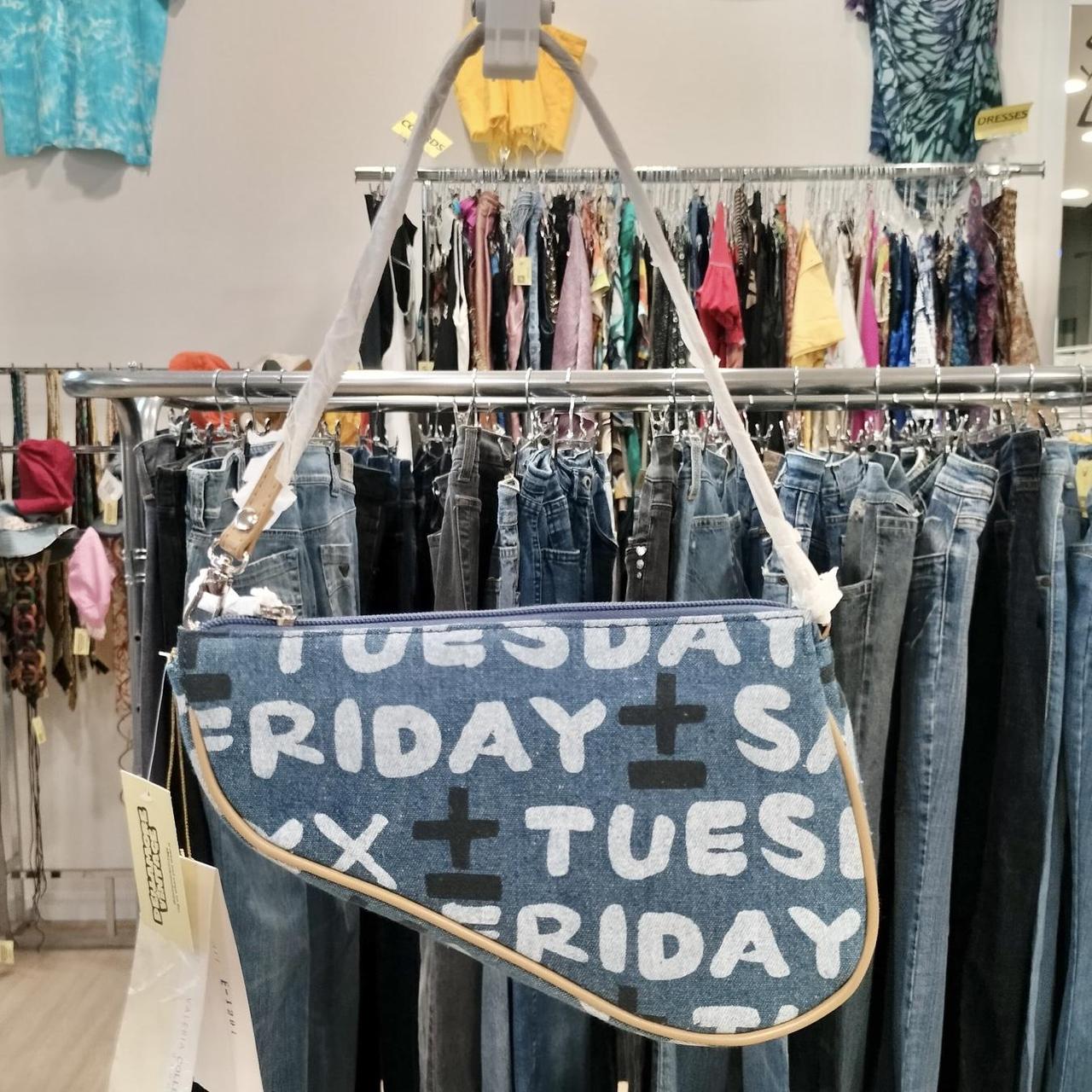 Blue denim bag with text hanging in a clothing store