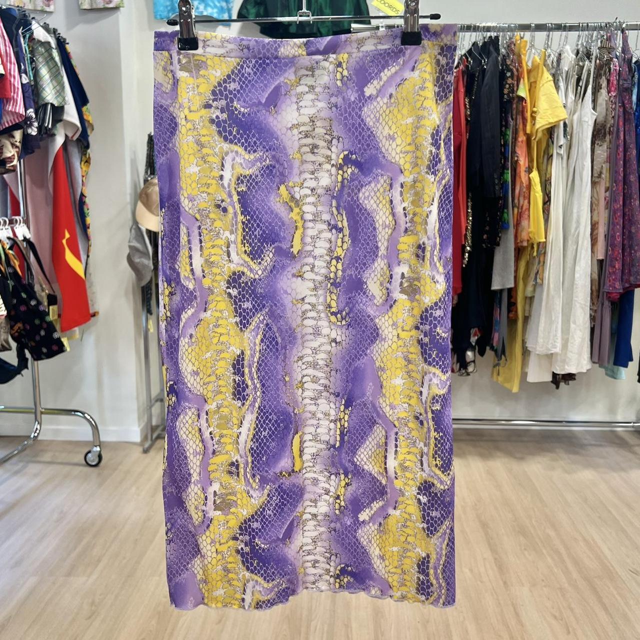Purple and yellow patterned skirt hanging on a rack in a clothing store