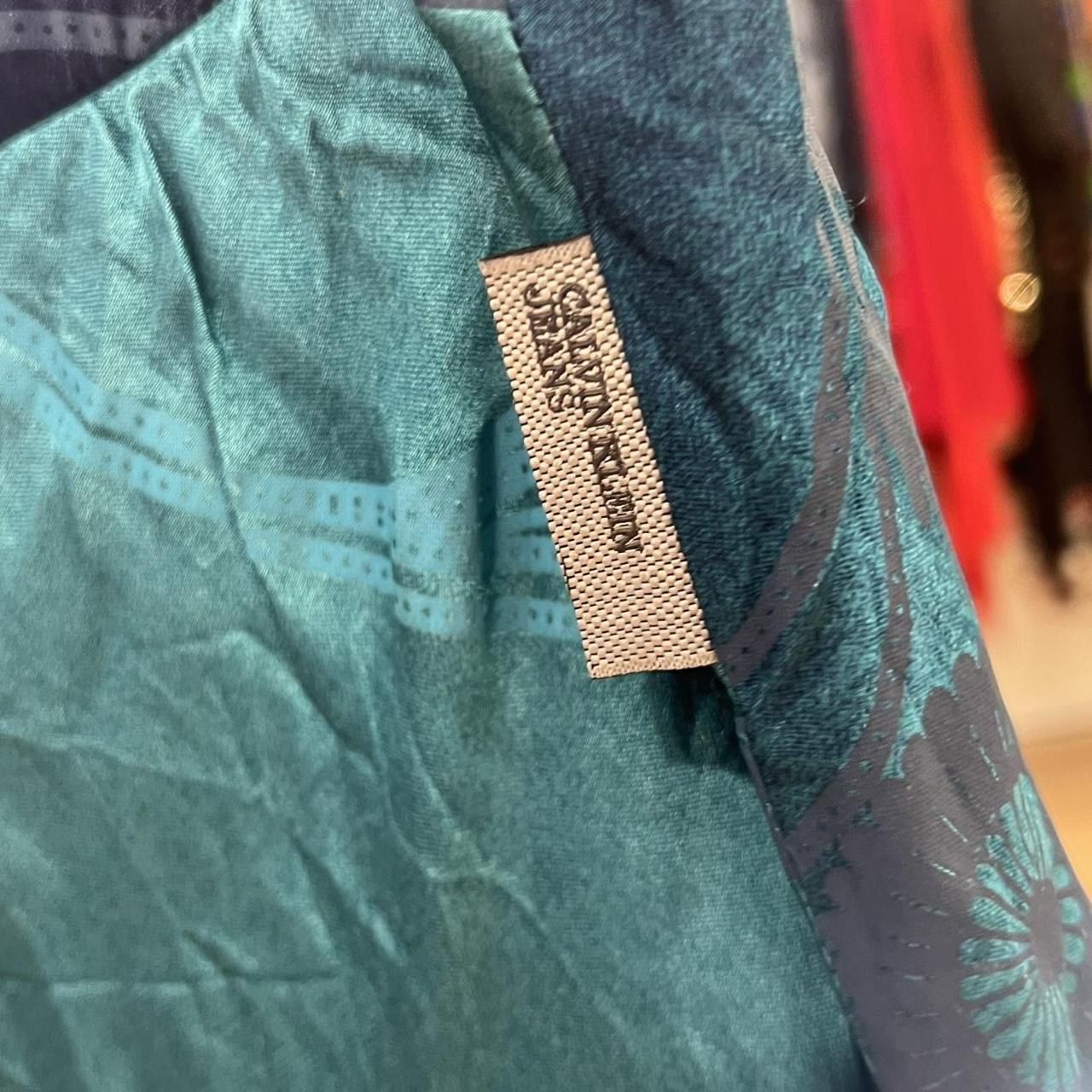 Close-up of a green denim fabric with a Calvin Klein label