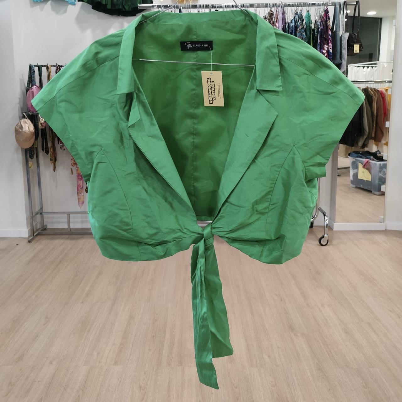 Green shirt with a tag on a wooden floor in a store setting