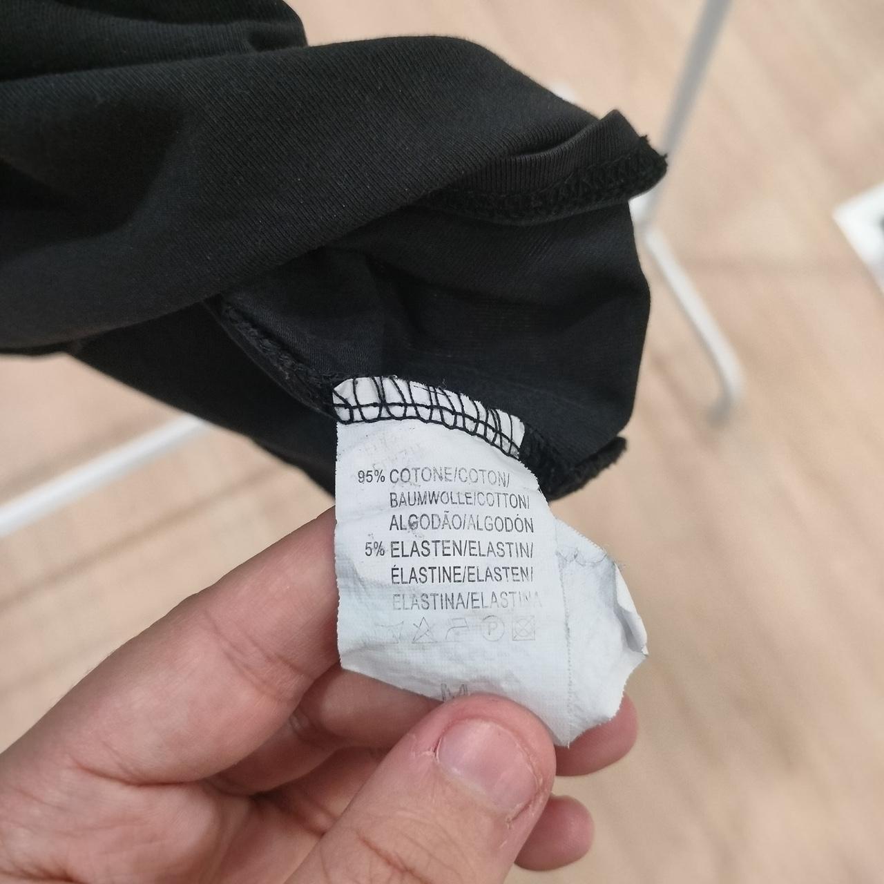 Clothing label held by a hand with a blurred background
