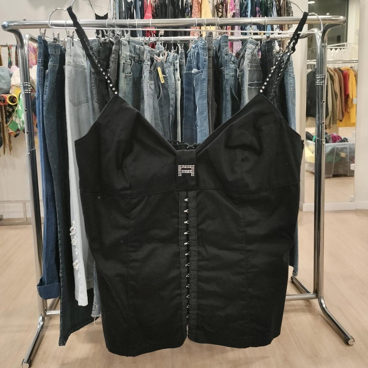 Black dress with decorative elements on a clothing rack in a store