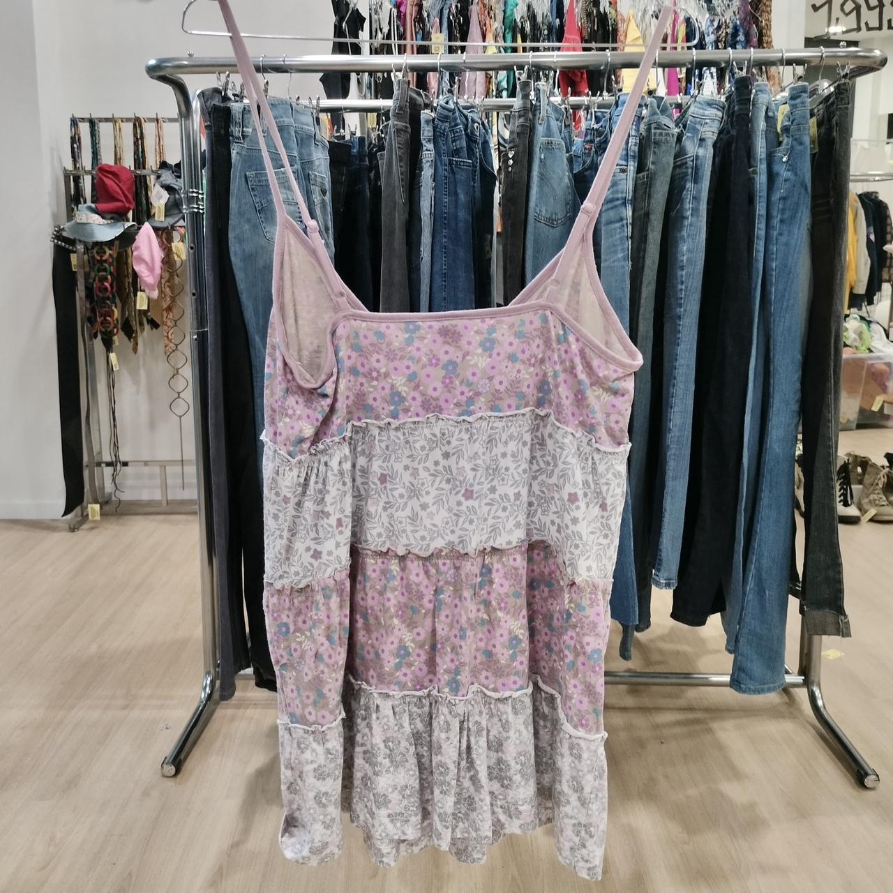Floral tiered sundress with lace details on hanger, surrounded by second hand jeans