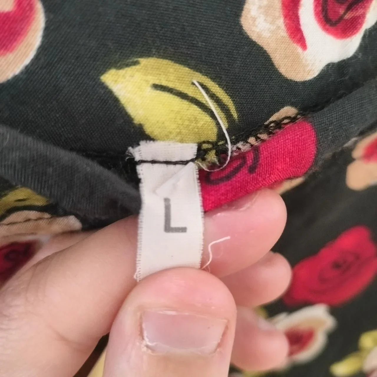 Close-up of a floral fabric with a clothing size tag labeled L