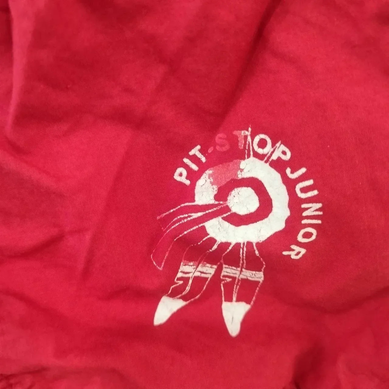 Red fabric with white Pit Stop Junior logo and racing graphic, sustainable fashion