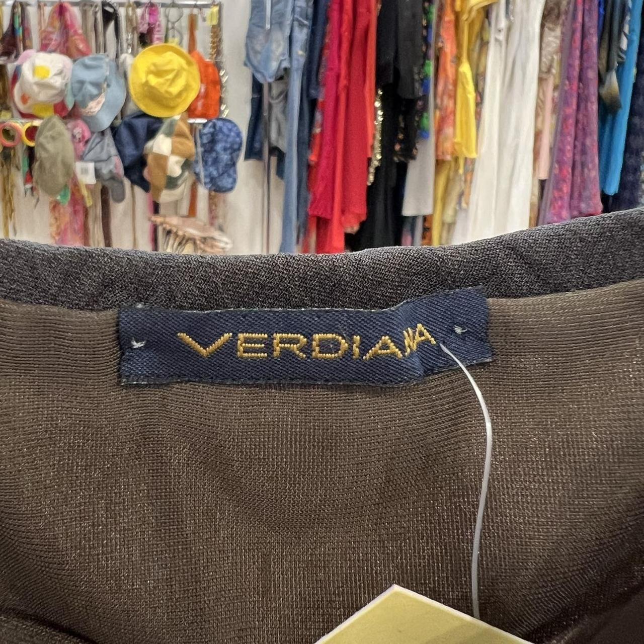 Verdiana clothing label on brown sustainable fashion item, colorful vintage clothes in background