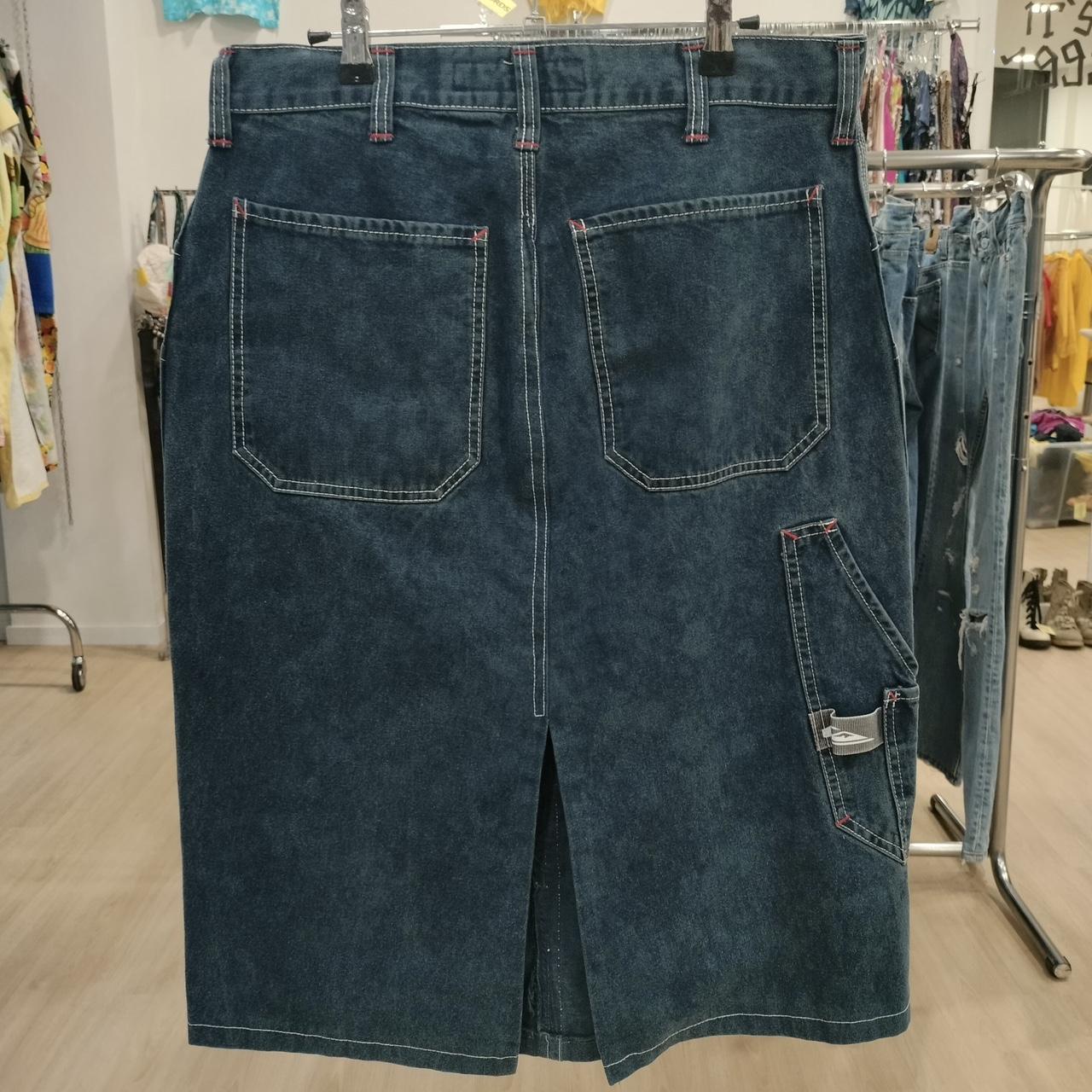 Blue denim skirt on a hanger in a store setting