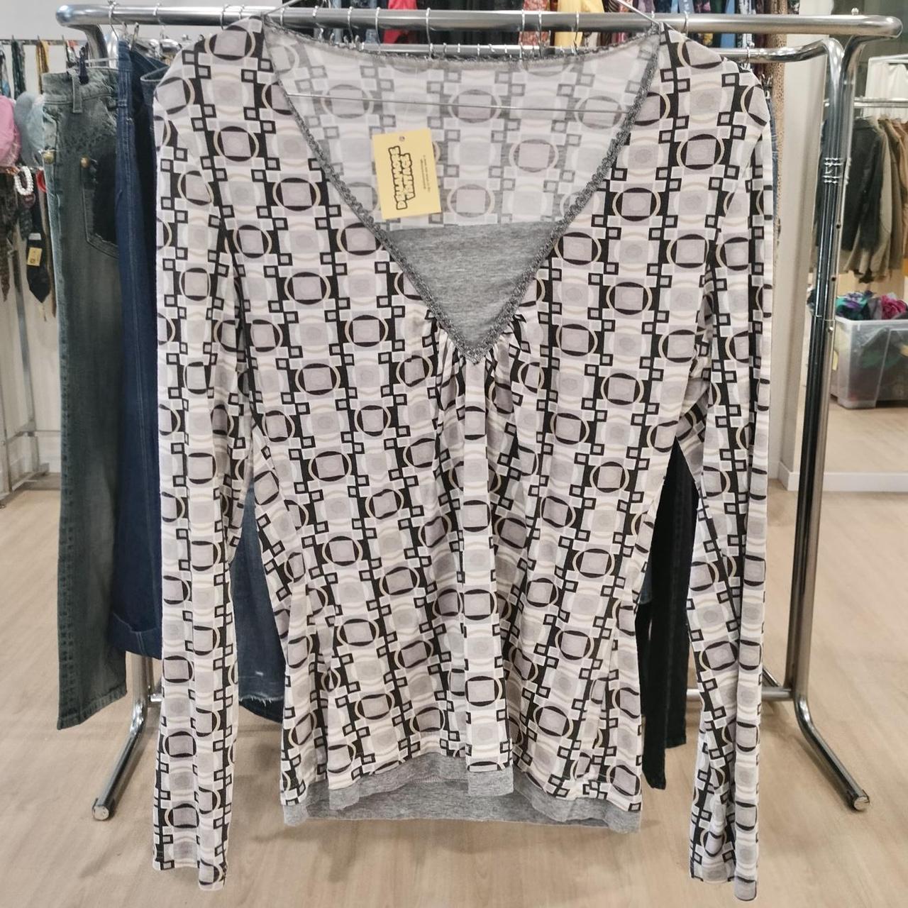 Geometric pattern long sleeve second hand blouse on rack in sustainable fashion store