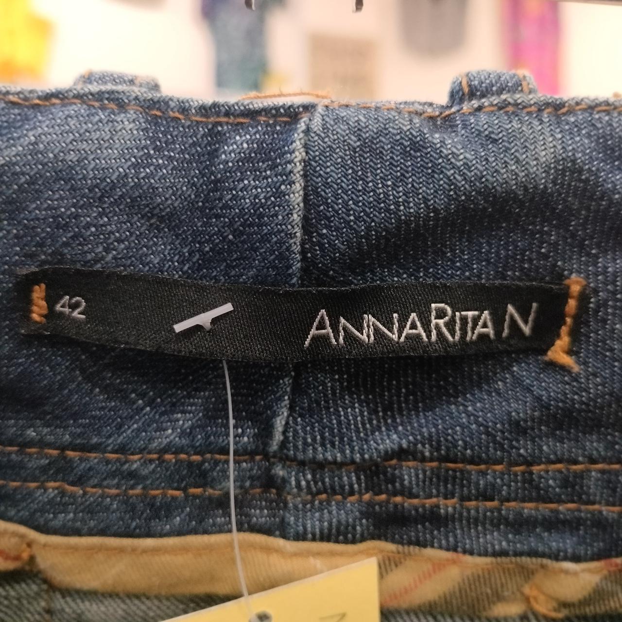 Close-up of a denim garment with ANNARITAN brand label and size 42 tag