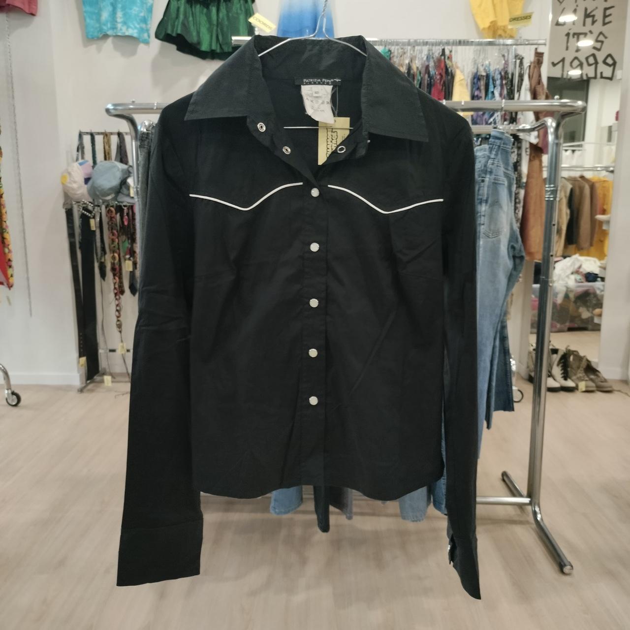 Black jacket with white trim on a rack in a clothing store