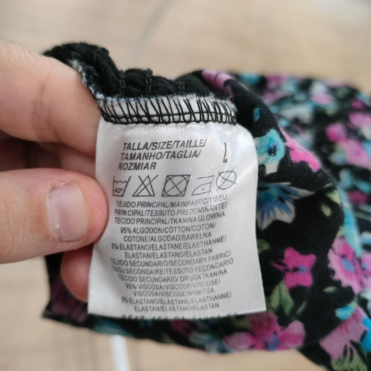 Close-up of clothing care label with washing instructions and floral fabric