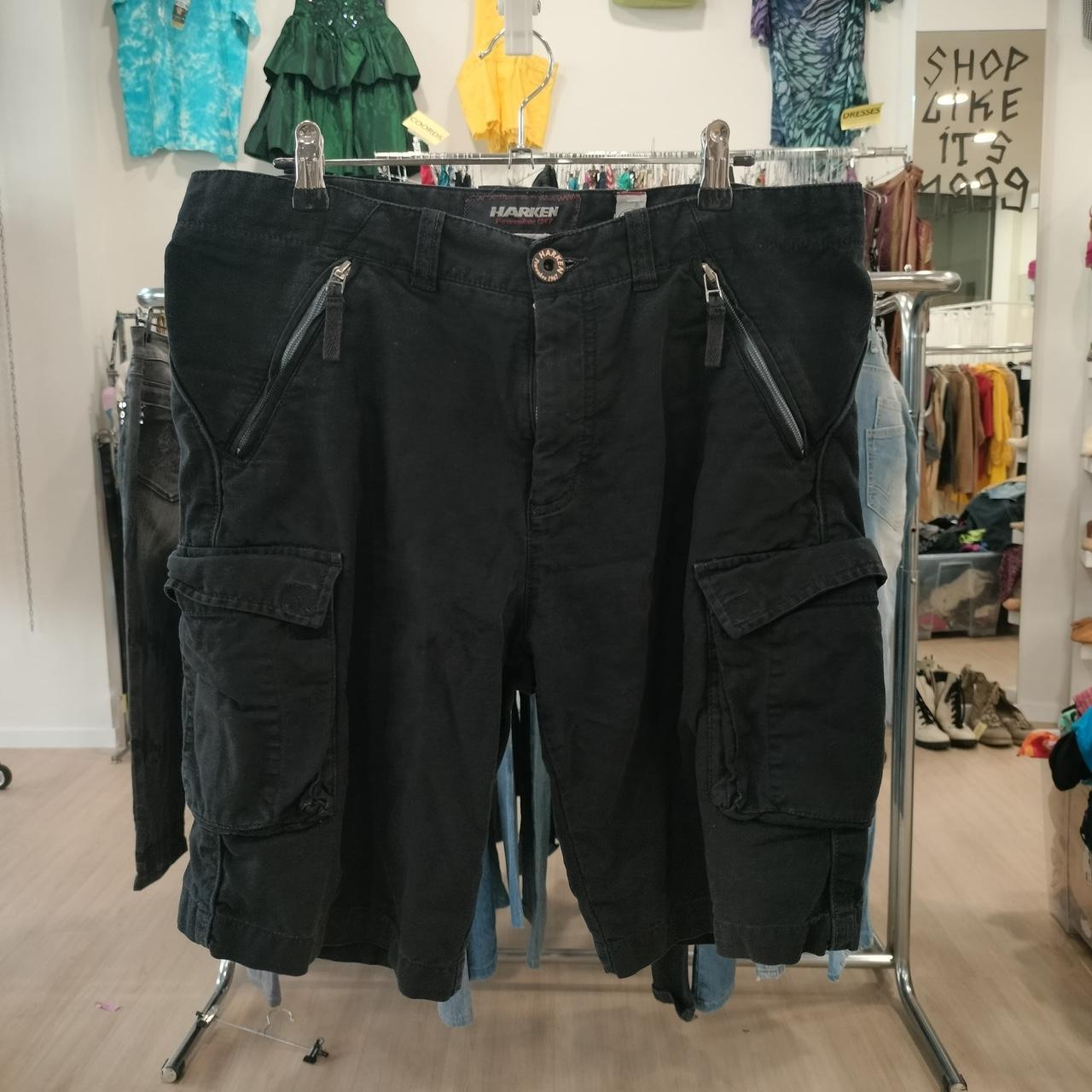 Black cargo shorts with multiple pockets displayed in a second hand clothing store