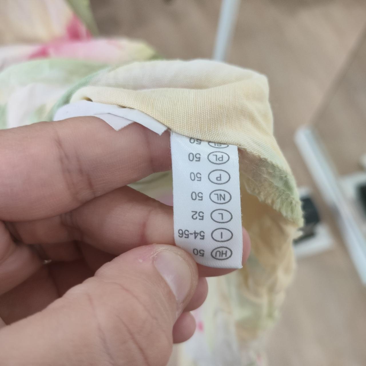 Close-up of a clothing tag held by a hand with a blurred background