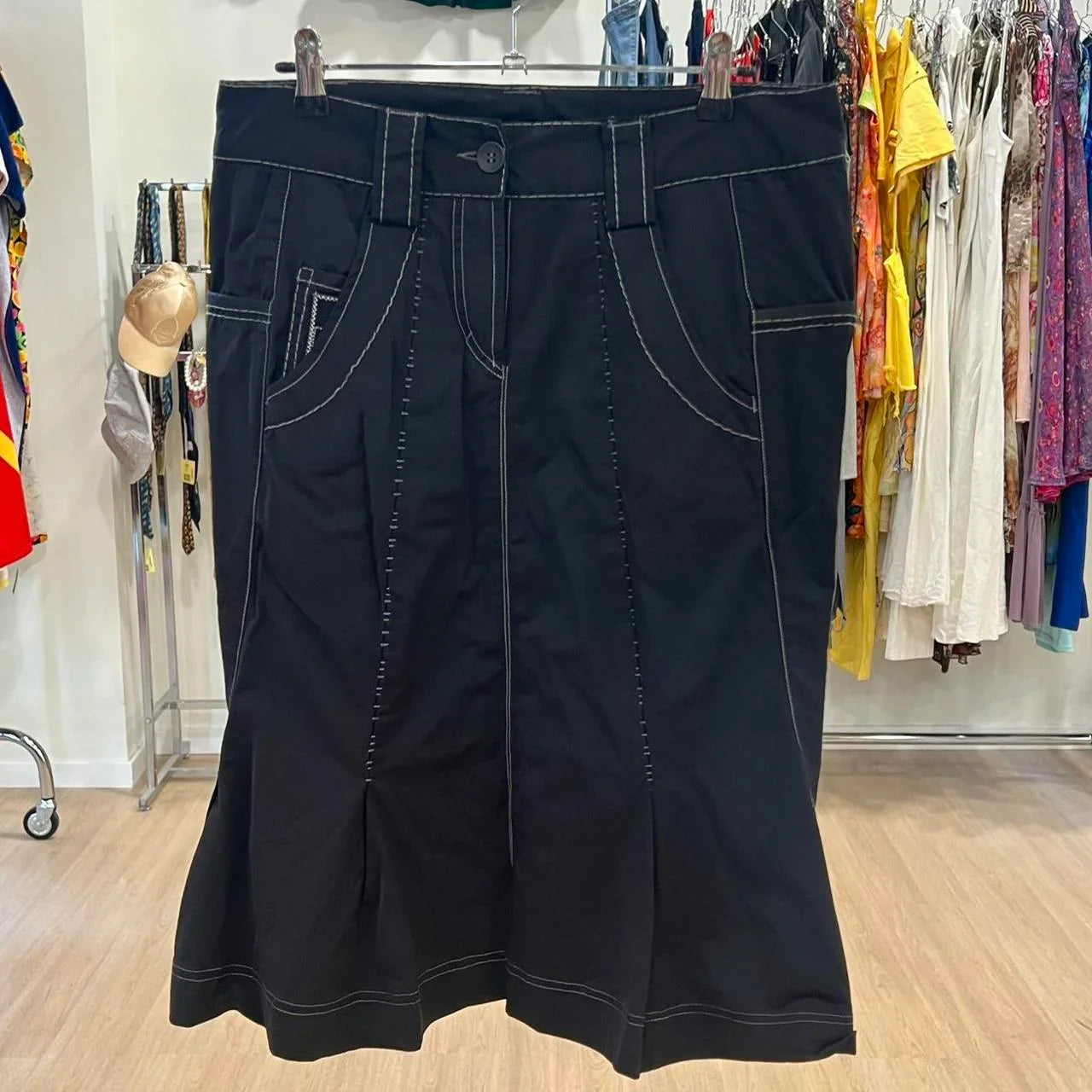 Black denim skirt with contrast stitching on hanger in second hand clothing store