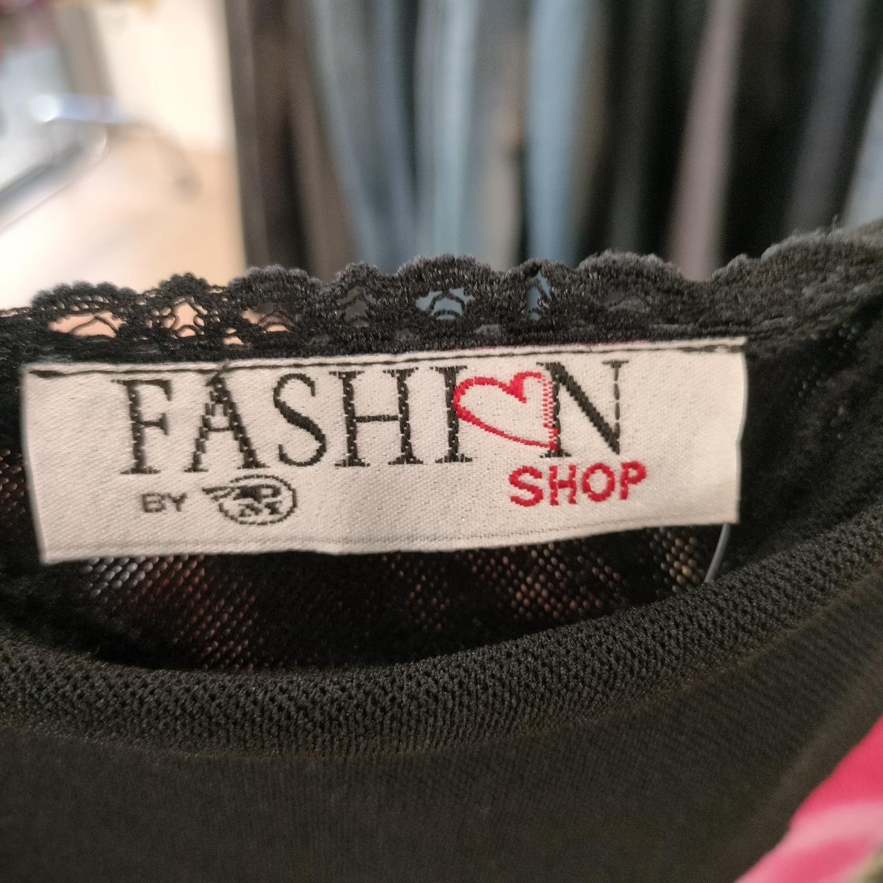 Close-up of a black lace garment with a label reading 'Fashion by Love Shop'
