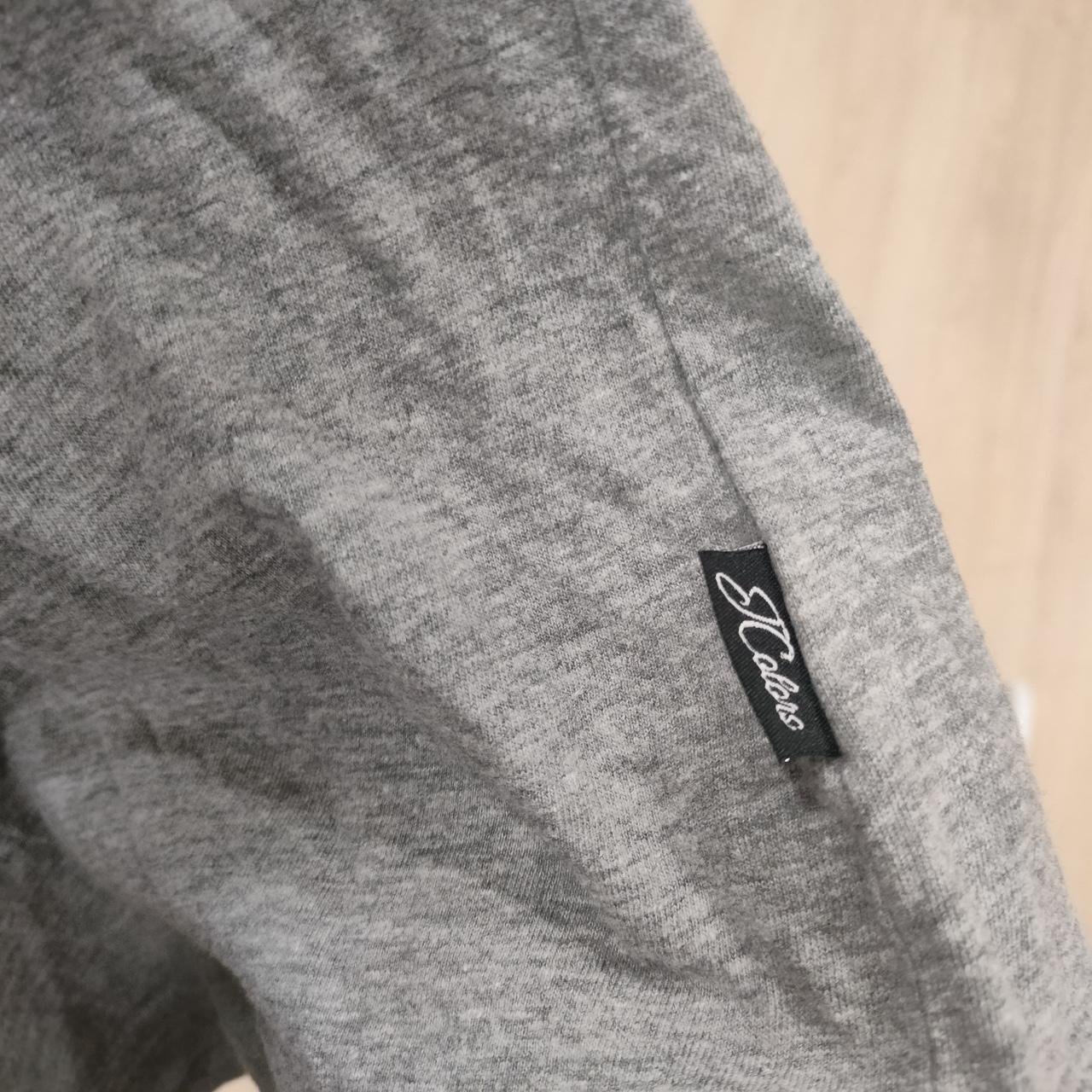 Close-up of grey sustainable fashion shirt with black label on wooden background