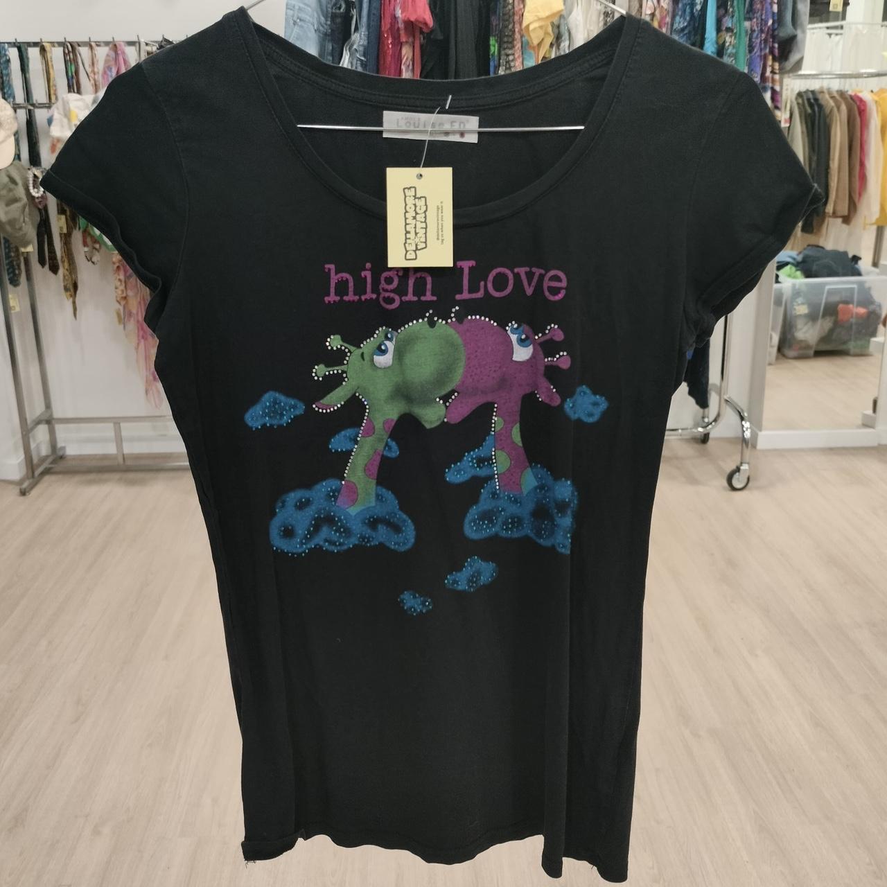 Black t-shirt with colorful giraffes design and 'high Love' text on a clothing rack