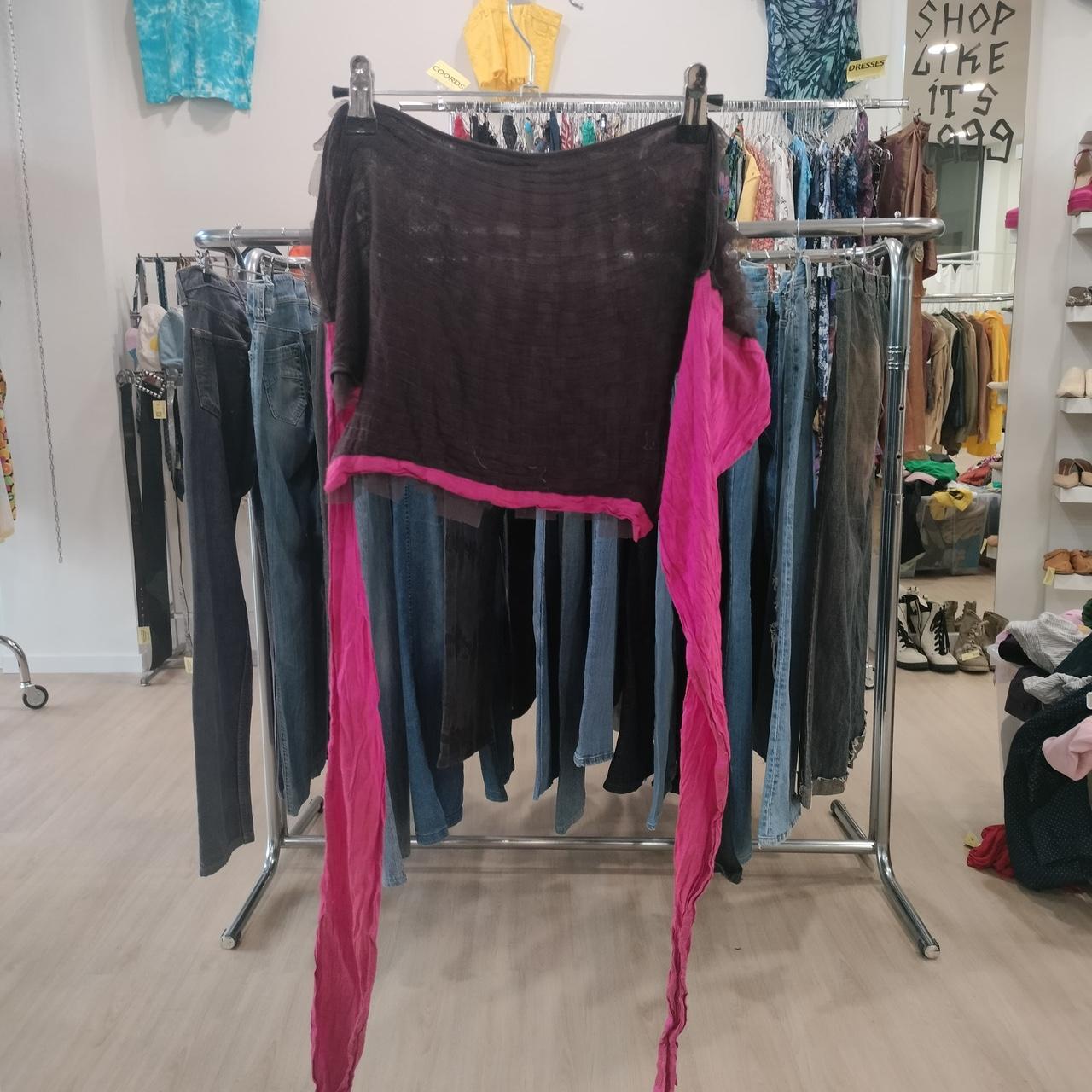 Black sheer crop top with long pink sleeves displayed in a second hand fashion store
