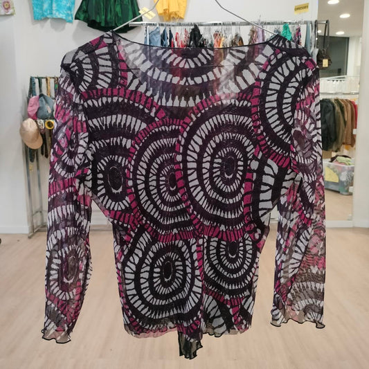 Sheer long sleeve top with bold circular black and magenta pattern, displayed in boutique