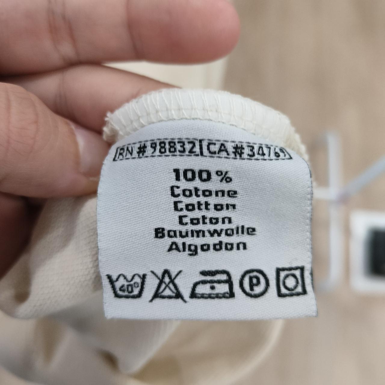 Clothing label with text and symbols on a beige background