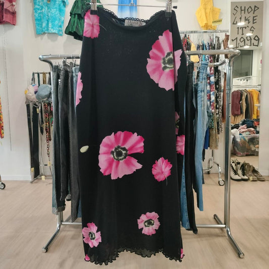Black dress with pink floral patterns on a clothing rack in a store
