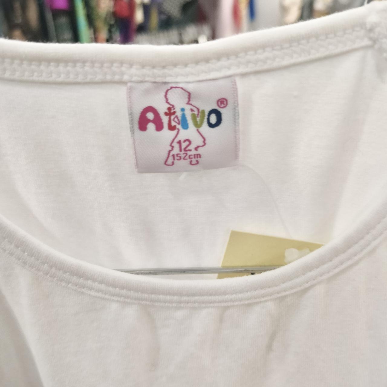 White children's shirt with Ativo size 12 label, 152 cm, in a second hand clothing store