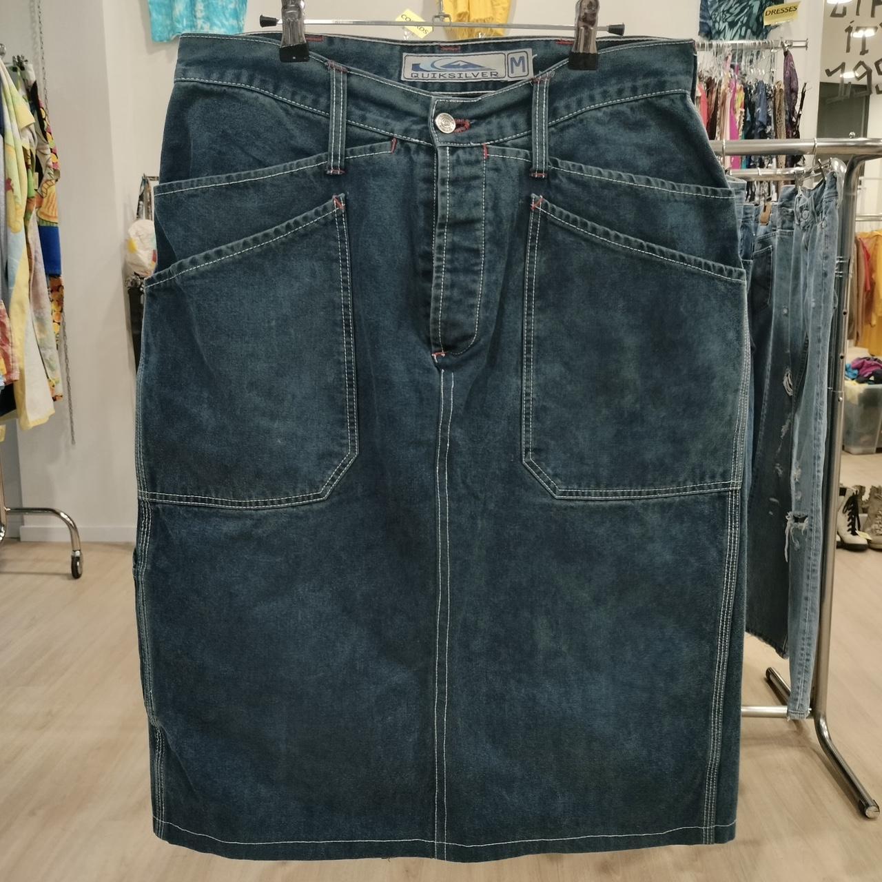 Blue denim skirt on a hanger in a store setting