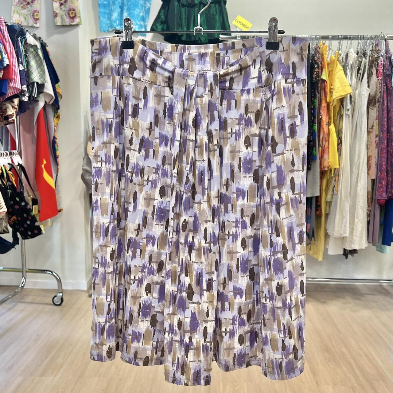 Patterned skirt hanging on a rack with clothing in the background