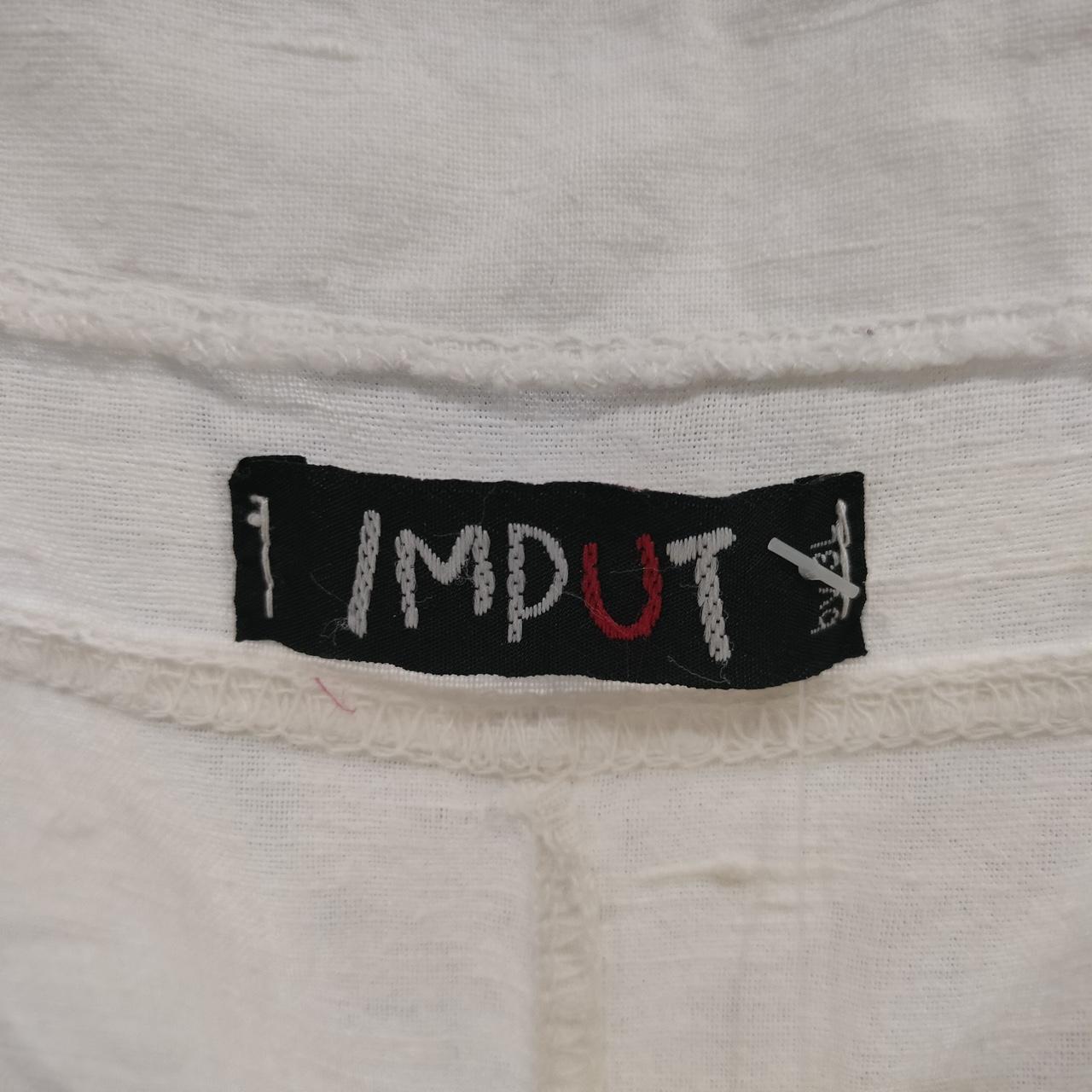 Close-up of IMPUTY clothing label on white sustainable fabric