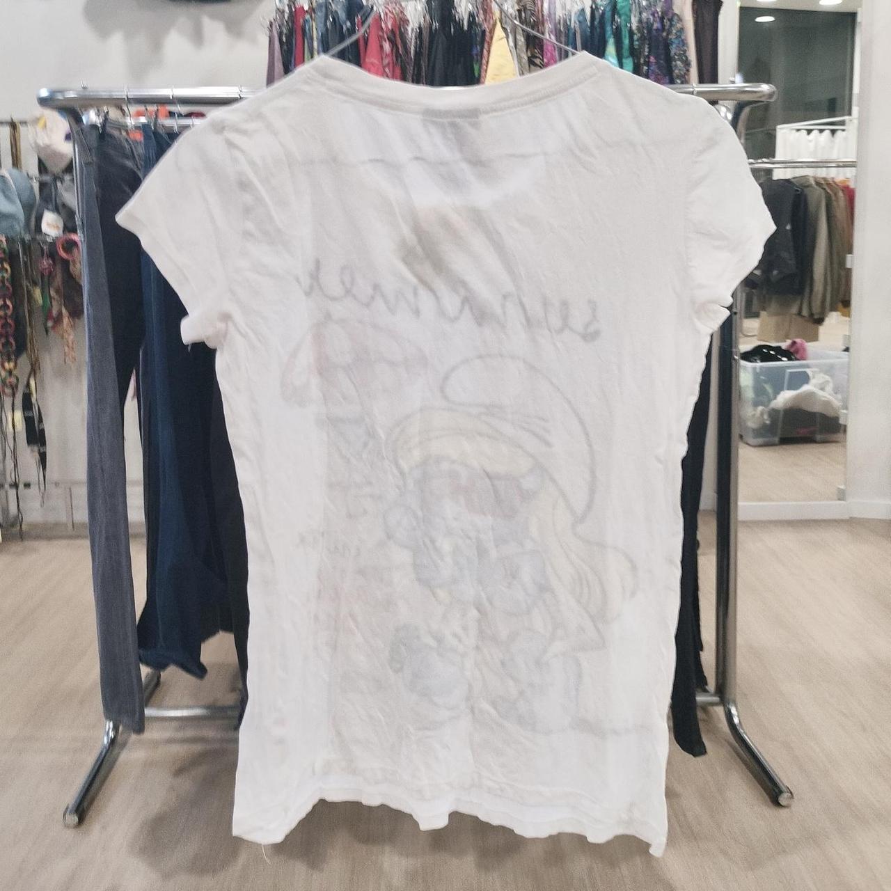 White short sleeve graphic t-shirt displayed in a second hand clothing store