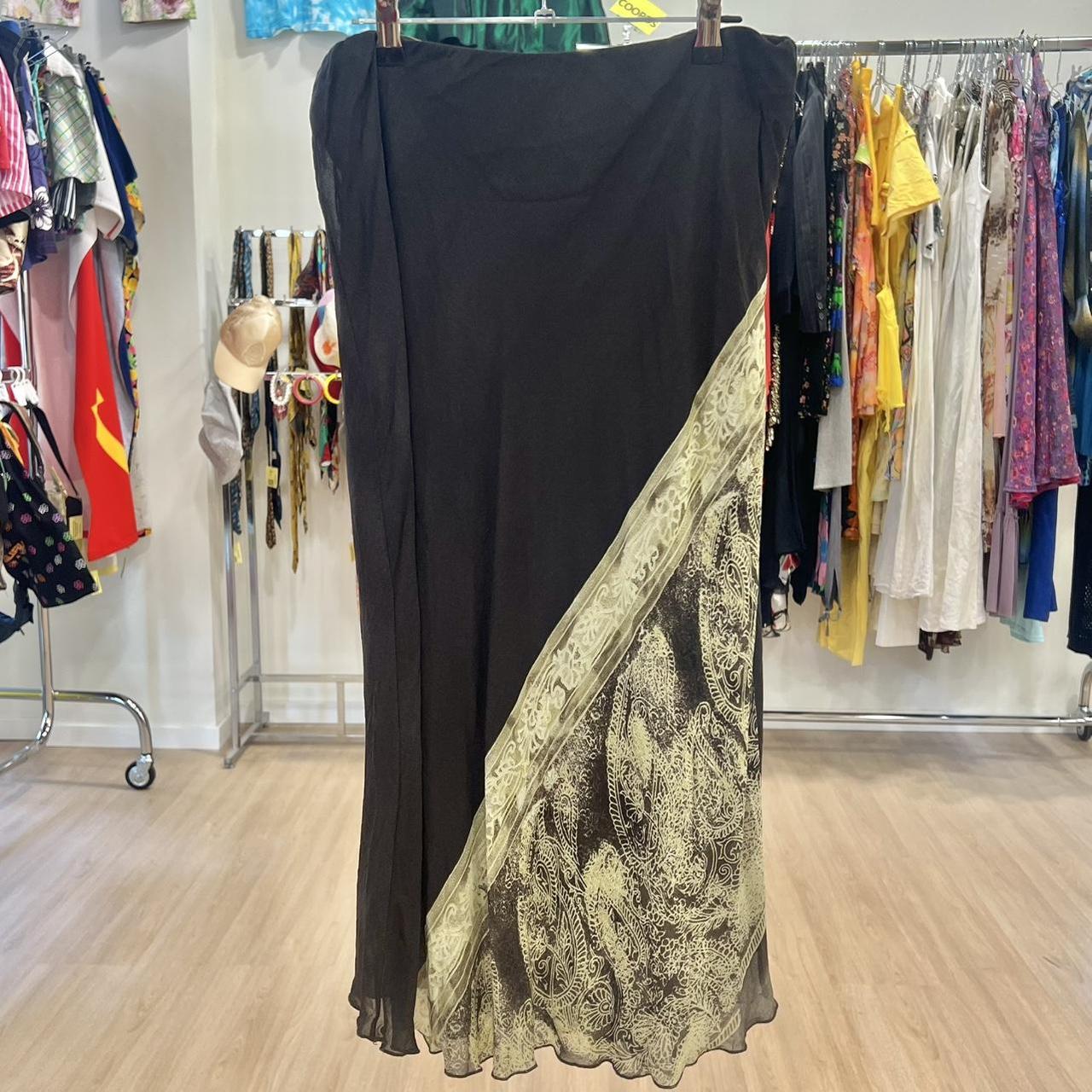 Black midi skirt with sheer paisley patterned panel, displayed in a second hand fashion store