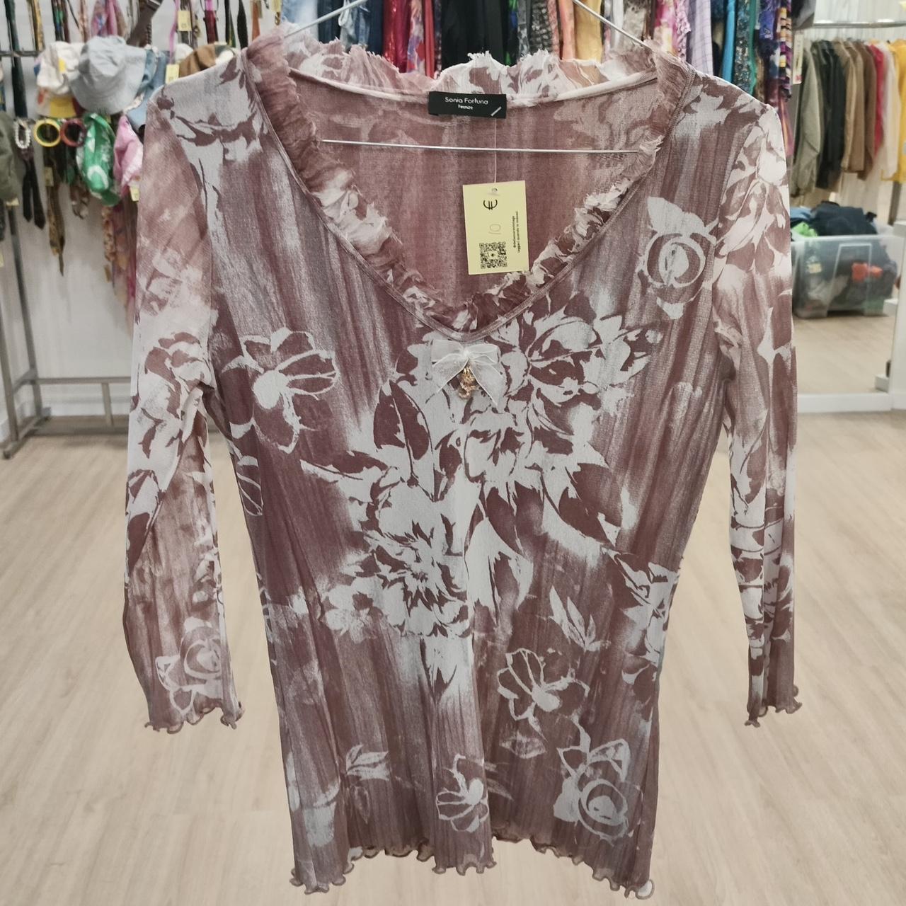 Sheer long sleeve floral top in mauve and white with ruffled V-neck, displayed in boutique