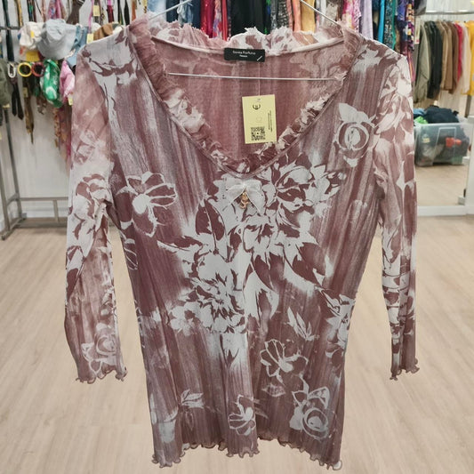 Sheer long sleeve floral top in mauve and white with ruffled V-neck, displayed in boutique