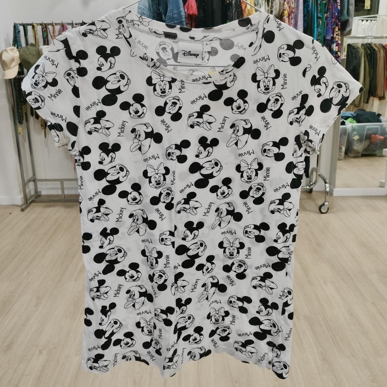White T-shirt with black Mickey and Minnie Mouse print, displayed in a second hand clothing store