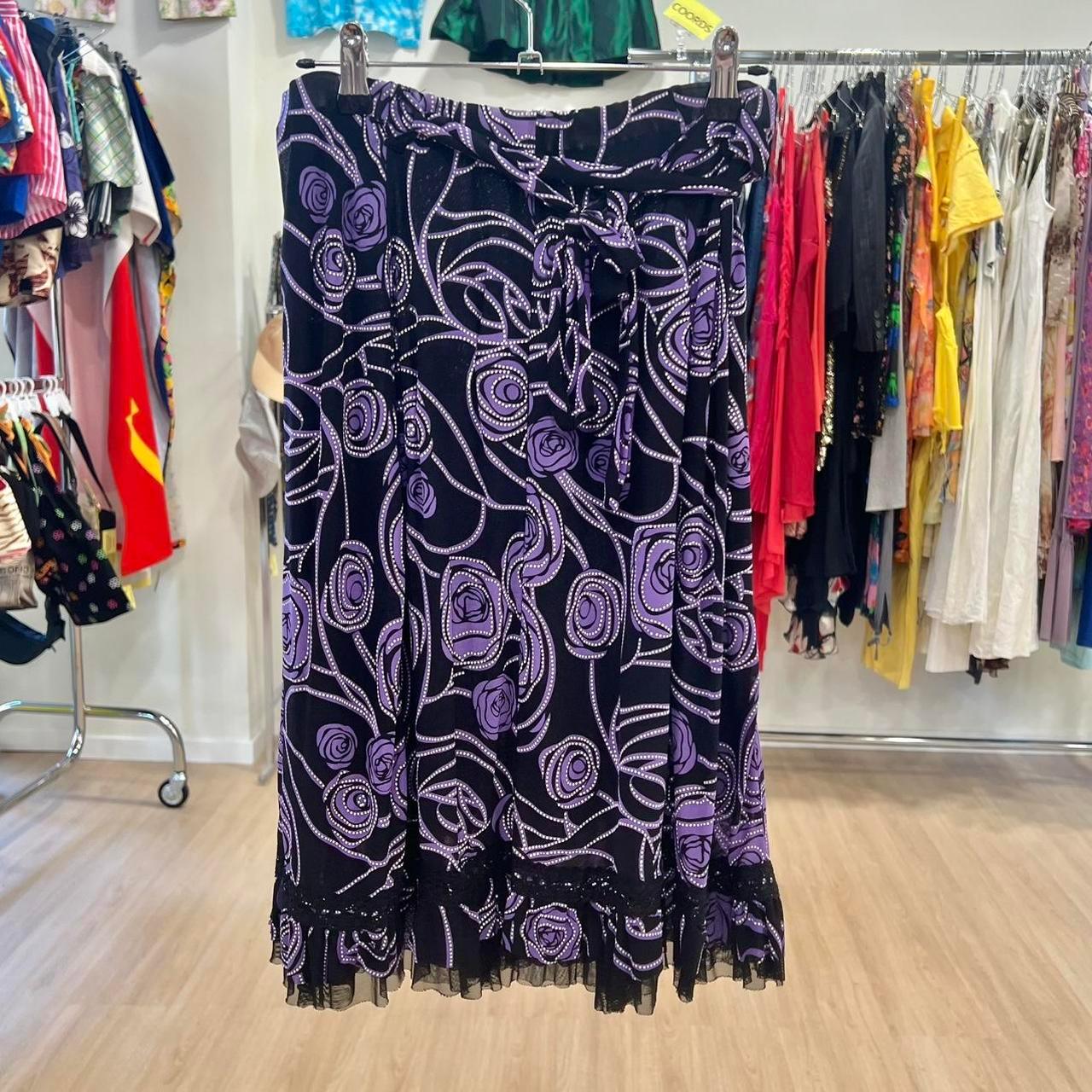 Purple and black floral skirt with swirl pattern, second hand fashion, hanging in boutique
