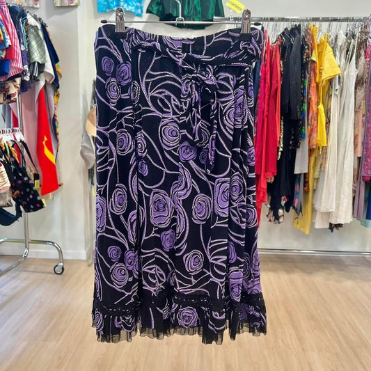 Purple and black floral skirt with swirl pattern, second hand fashion, hanging in boutique