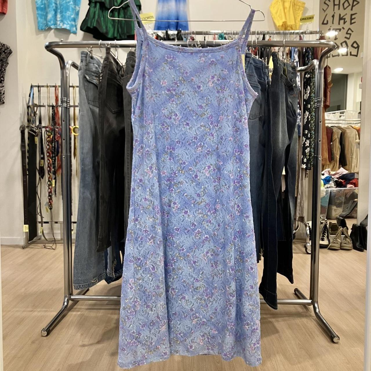 Light blue floral slip dress on hanger in a second hand fashion store