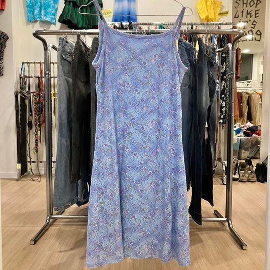 Light blue floral slip dress on hanger in a second hand fashion store