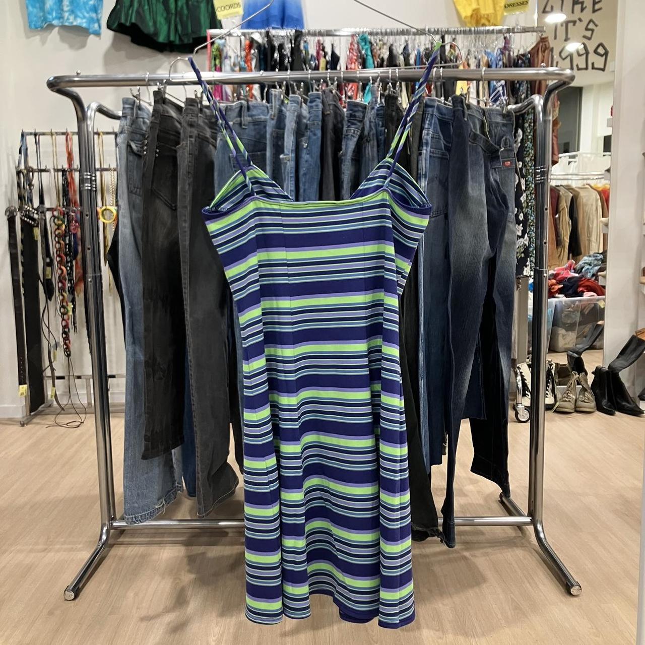 Striped dress hanging on a rack with jeans in a store setting