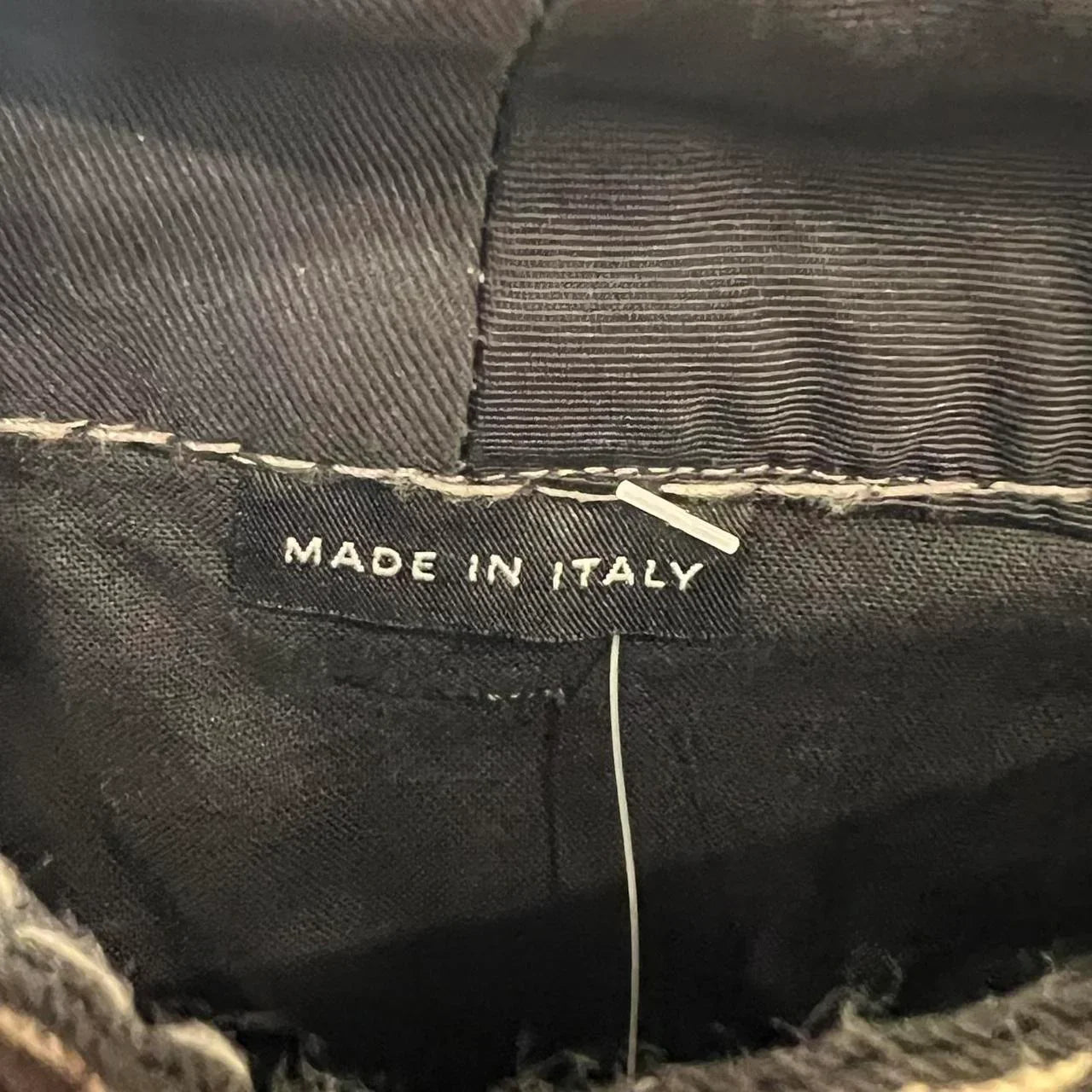 Black clothing label with white 'Made in Italy' text on garment interior
