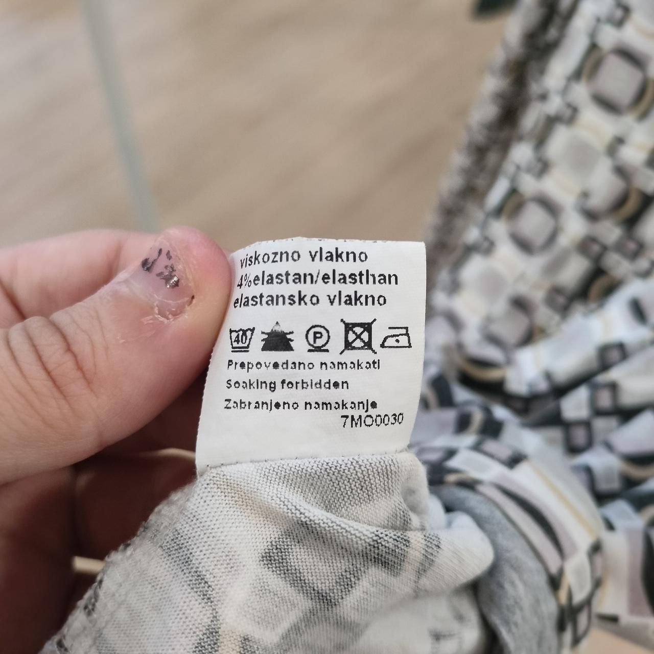 Close-up of a fabric care label with washing instructions on patterned sustainable fashion garment