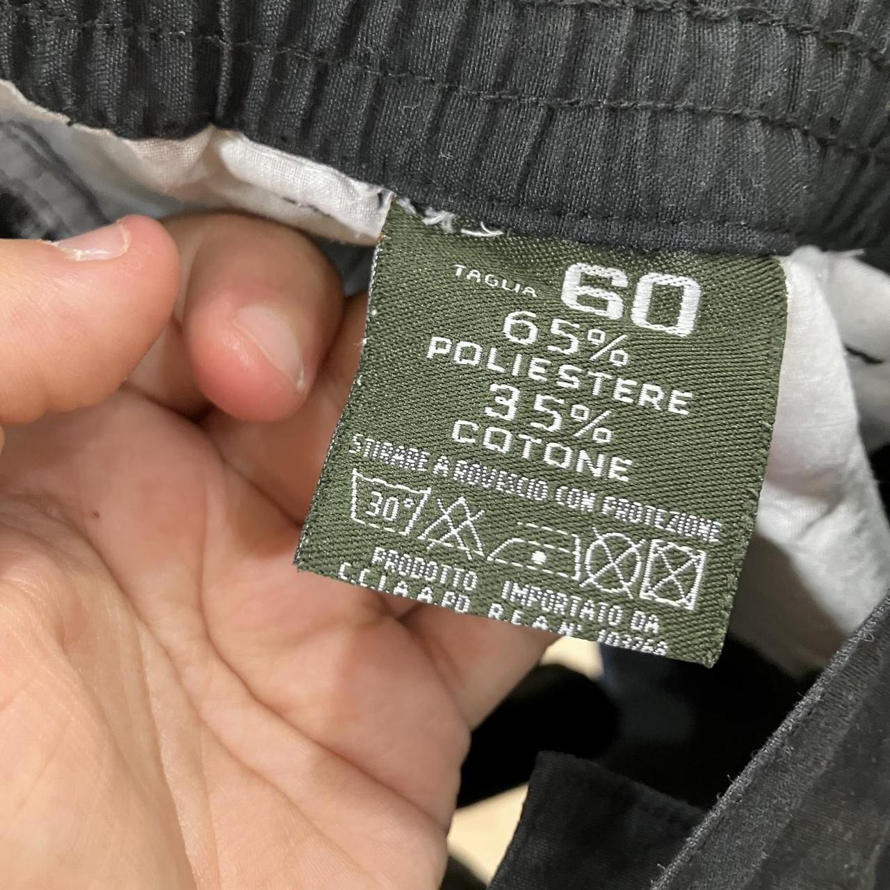 Clothing label with fabric composition details held by a hand