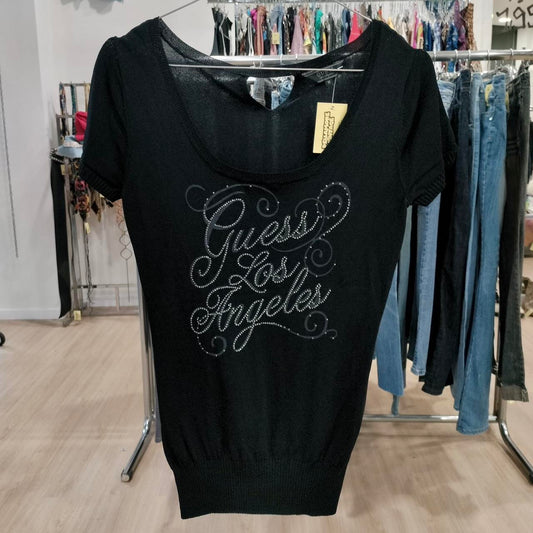 Black dress with 'Guess Los Angeles' text on a rack in a store setting