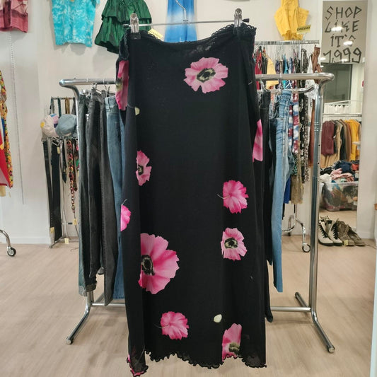 Black dress with pink floral patterns on a rack in a store setting